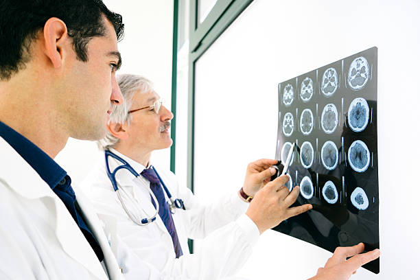 Doctors Consult Over An MRI Scan Of The Brain Doctors consult over an MRI scan of the brain. infarction photos stock pictures, royalty-free photos & images