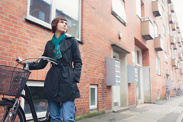 mujer con bicicleta en la zona residencial de copenhague, dinamarca. - amager fotografías e imágenes de stock