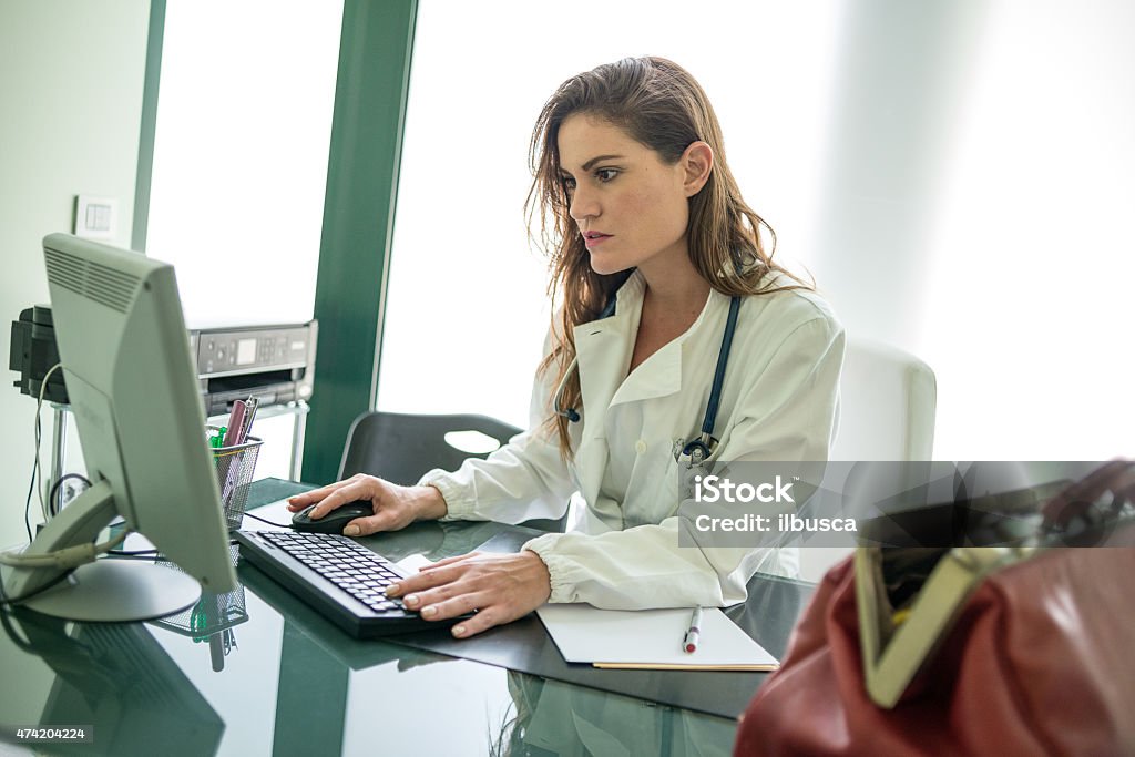 Female doctor using computer in her office 20-29 Years Stock Photo