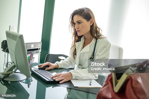 Female Doctor Using Computer In Her Office Stock Photo - Download Image Now - 20-29 Years, 2015, 30-39 Years