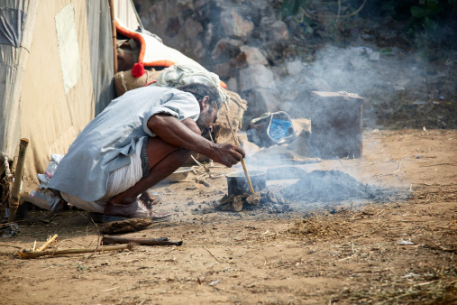 Camel herder cooking over an open wood fire