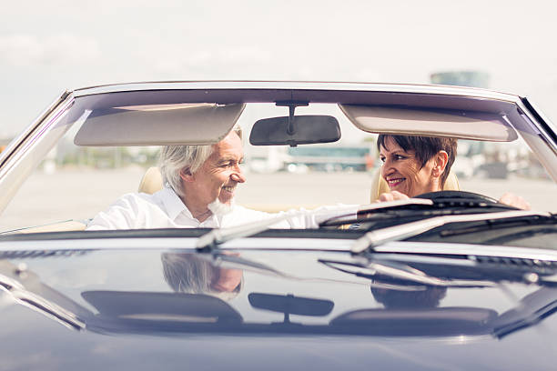 istock senior couple driving a convertible classic car 474211902
