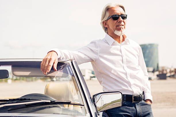 istock senior man standing next to convertible classic car 474211940