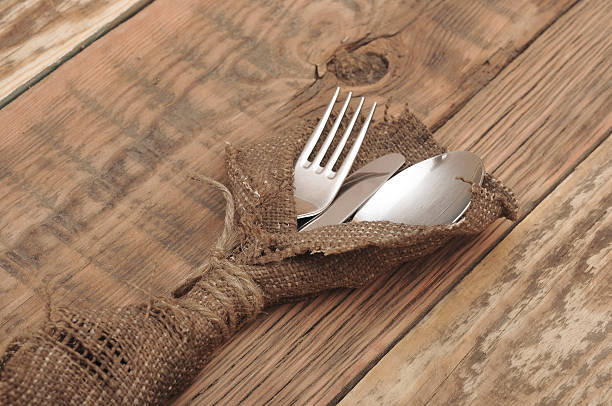 istock knife and fork in rough old sacking over wood 474213647