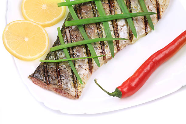 istock Grilled carp fillet on plate with onion and lemon. 474213791