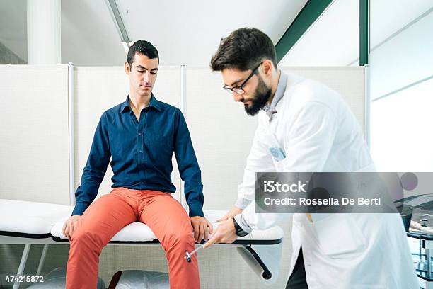 Physical Therapist Examining Patients Reflexes With Reflex Hammer Stock Photo - Download Image Now