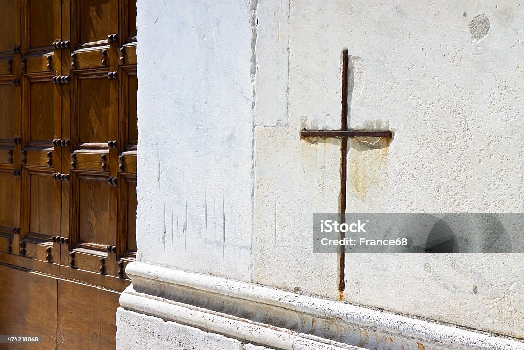 Iron cross snuggled in white stone Iron cross snuggled in white stone on a italian facade church 2015 Stock Photo