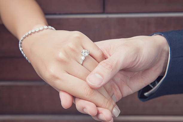 holding hand with diamond ring holding hand with diamond ring, wedding proposal diamond ring photos stock pictures, royalty-free photos & images