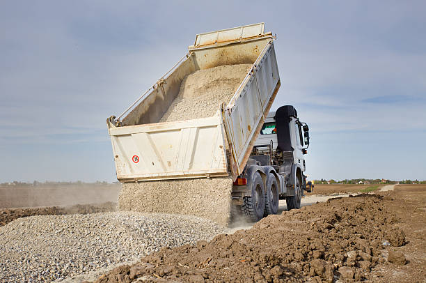 Truck tipping gravel Tipping truck unloading gravel on road construction site gravel photos stock pictures, royalty-free photos & images