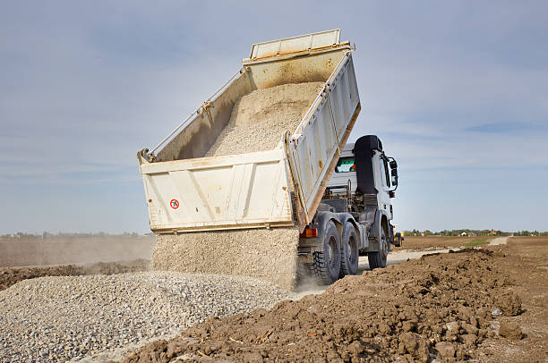 Truck tipping gravel Tipping truck unloading gravel on road construction site gravel mound stock pictures, royalty-free photos & images