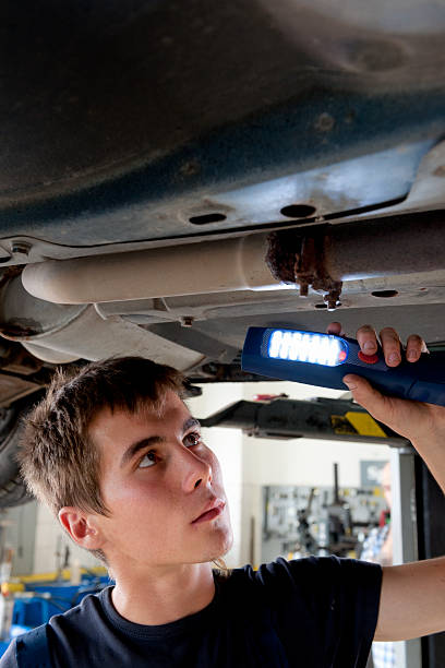 porträt eines jungen, die auto mechaniker auto reparieren shop - maintenance engineer car lamp protective workwear stock-fotos und bilder