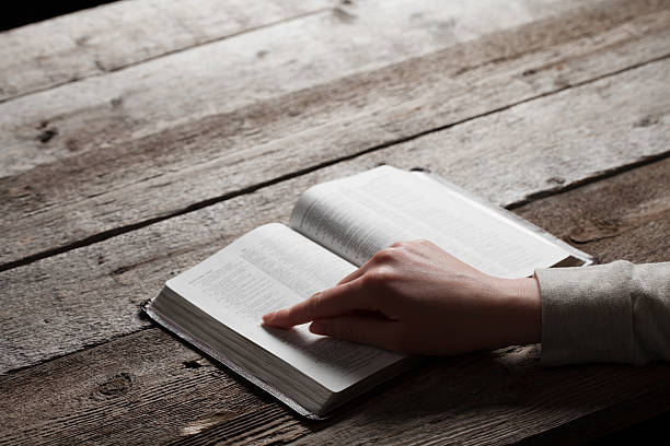 istock woman finger presses on bible book 474224138