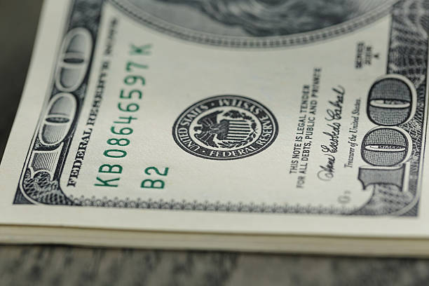 istock hundred dollar bills on wood table 474228286