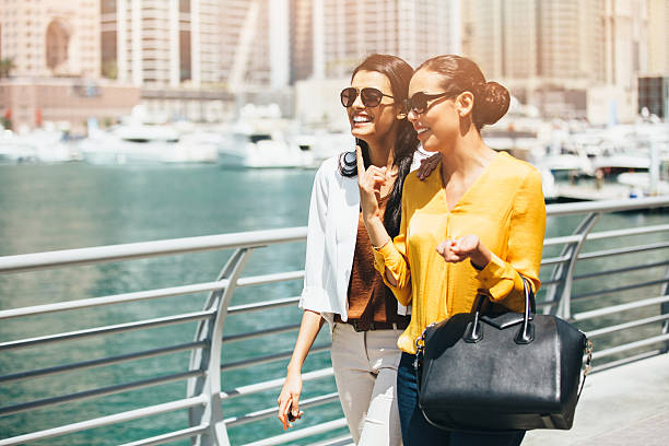 Friends walking outdoors Two friends walking outside during a lovely sunny day. They are talking about some gossip and enjoying the day. arabian sunglasses stock pictures, royalty-free photos & images