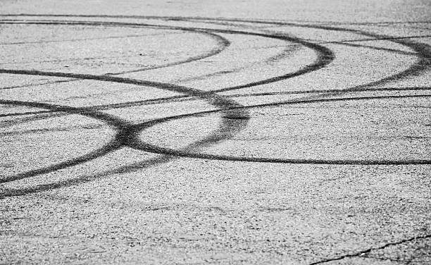 istock Dark tire tracks on gray asphalt road 474233410