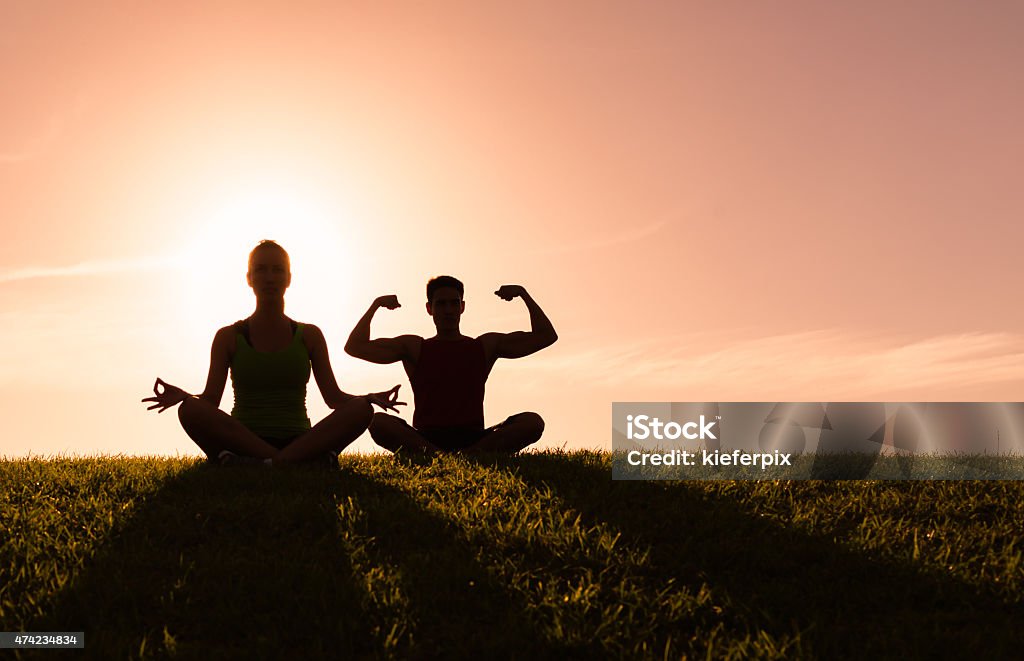 Couple doing yoga outdoors Young people do yoga outdoors. 2015 Stock Photo