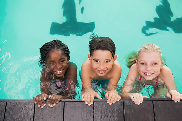 istock Cute swimming class in pool with coach 474235140