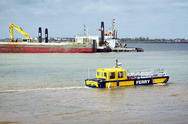 Tugboat in the river Thames dragging pontoon.