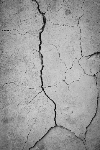 Grunge concrete cement wall with crack in industrial building