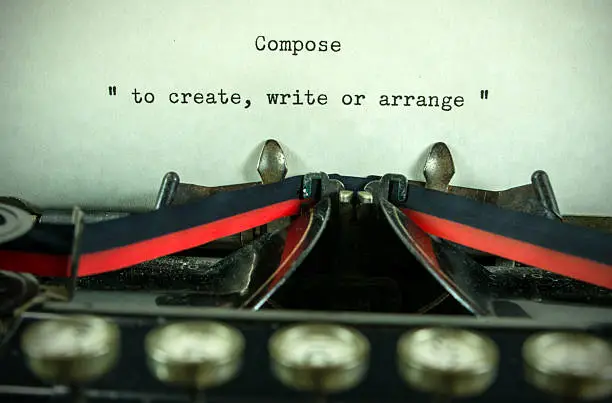 An antique typewriter with the definition of the word "compose"... copy space and vignetted.