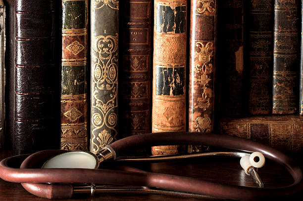 Very old stethescope and leatherbound medical books in a library 
