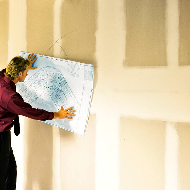 istock Businessman looking at office blueprints. 474264692