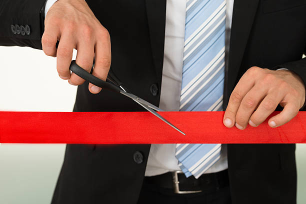 istock Businessman Cutting Red Ribbon With Scissors 474266700