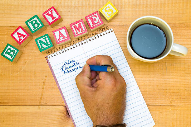 Writing out potential baby names drinking a coffee. stock photo