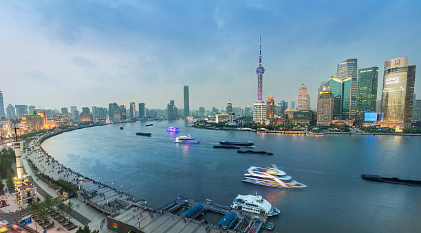 Shanghai Skyline at Night. High Angle View over the Bund, busy Huangpu River and the Famous Skyscrapers of the Financial District. Shanghai, China.
