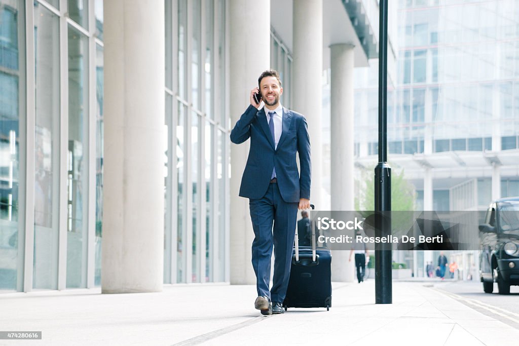 Businessman On His Cell Phone With Suitcase Businessman on his cell phone with suitcase. Suitcase Stock Photo