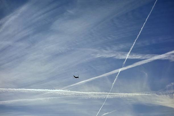 Vapor trail- A plane flying on a perfectly blue sky stock photo