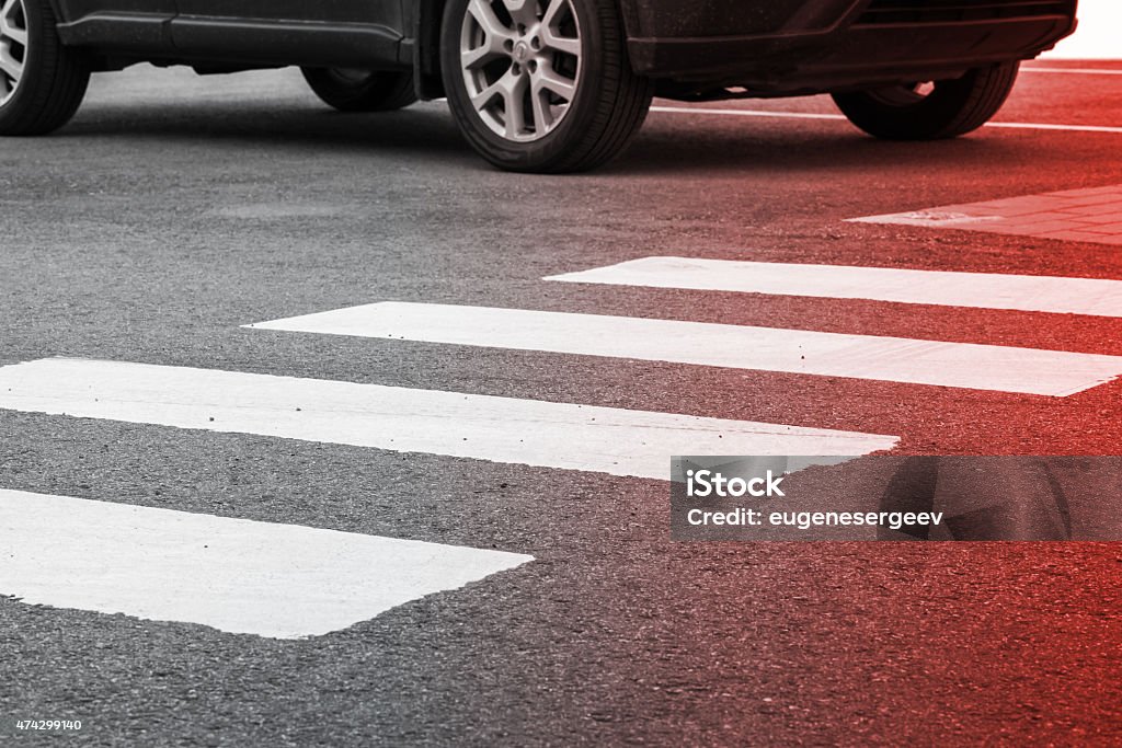 Pedestrian crossing road marking and moving car Pedestrian crossing road marking and moving car, photo with red gradient tonal filter, selective focus and shallow DOF Misfortune Stock Photo