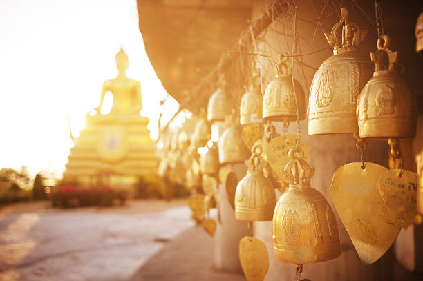 Sitting Buddha and buddhist bells Buddhist bells with wishes hanging in the temple near the sitting Buddha wat stock pictures, royalty-free photos & images