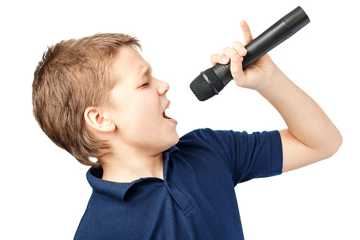 Teenage boy singing into a microphone on a white background. Very emotional.