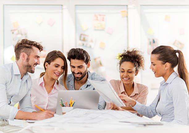 istock Group of young happy adults working in the office. 474325318
