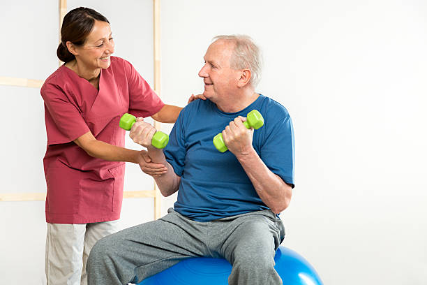 istock Physical Therapy - Female nurse with a senior man 474325998