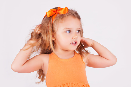 Portrait of a cute little girl in orange dress