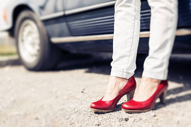 istock woman standing next to convertible classic car 474326408