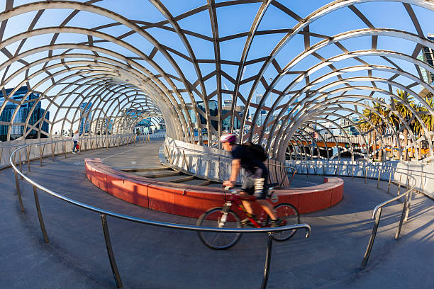 Cyclists riding over the Old IJsselbrug over the river IJssel between Zwolle and Hattem. View from the middle of the road on the old steel arch bridge.