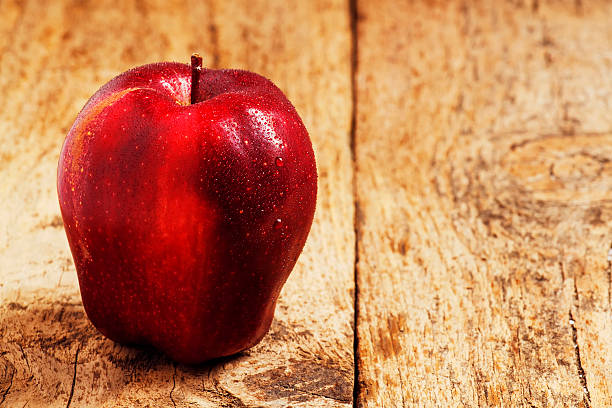 istock Red apples with water drops on a wooden table 474329928