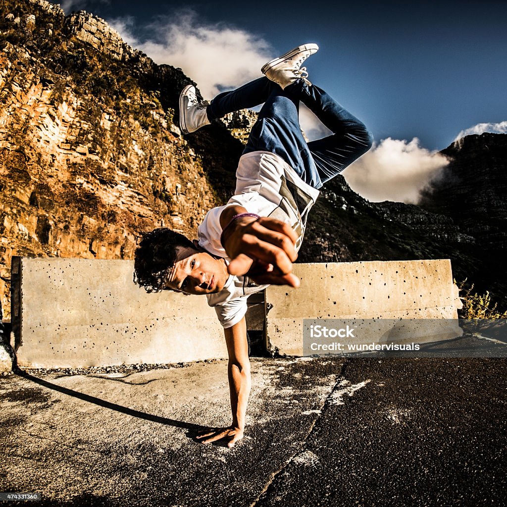 Hispanic b-boy breakdancer balancing on one hand and pointing at Hispanic breakdancer pointing at you while balancing on one hand Free Running Stock Photo