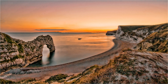 The iconic coastal cliffs around Lulworth  Dorset -  with Durdle Dor stretching out in the sea.  Taken at sunset in early Autumn.