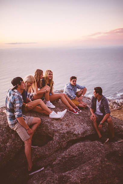 istock Teens sitting on rocks together at dusk 474331540
