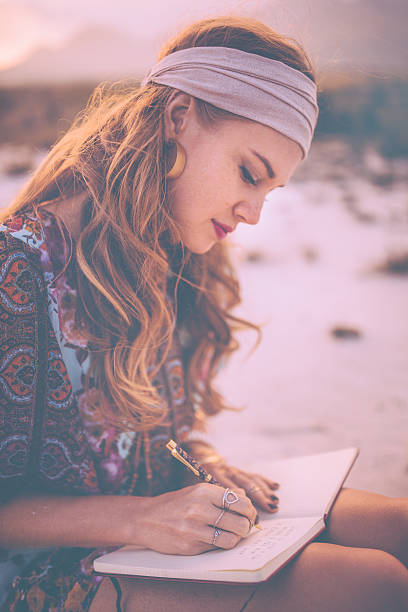 istock Boho girl writing in her journal while surronded by nature 474331612