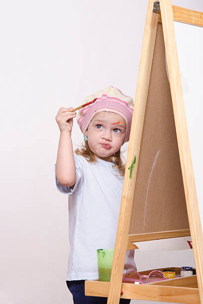 istock Girl artist paints on canvas 474331931