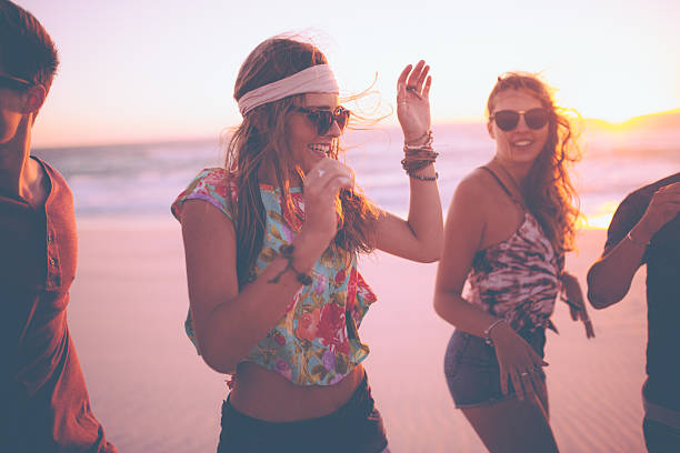 istock Boho Girls dancing at a summer evening beachparty 474333734