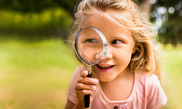 istock Exploring girl with magnifying glass in nature 474333774