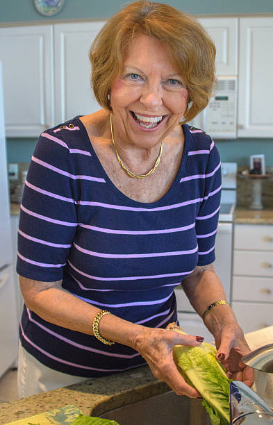 istock Happy Senior woman washing vegetables 474334637