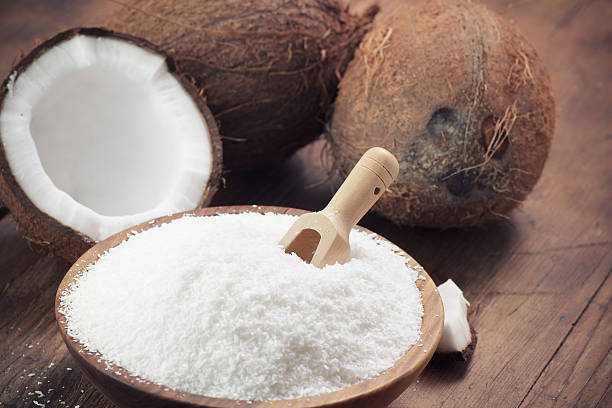 clos'up of a кокос и заземление кокосовыми хлопьями - powdered coconut стоковые фото и изображения