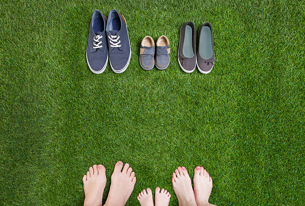 istock Family legs  standing  opposite shoes on  grass 474334766